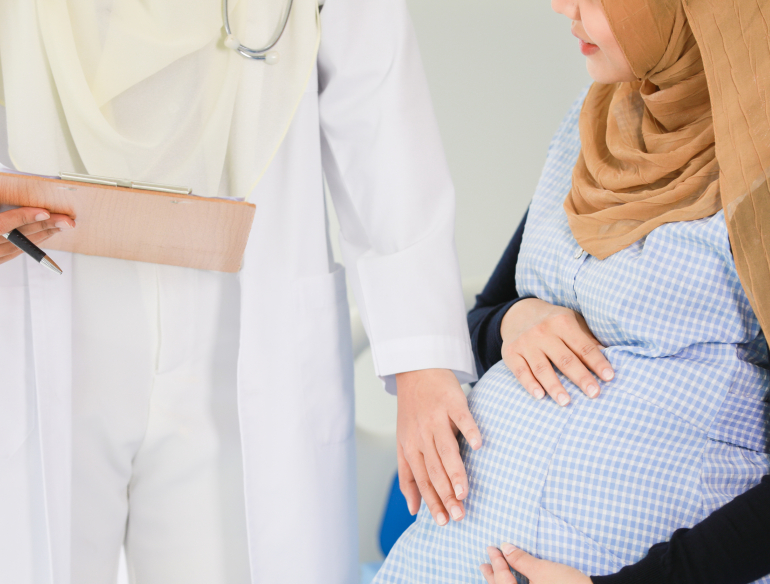 Muslim doctor touching the belly of a pregnant Muslim woman. Credit: AdobeStock