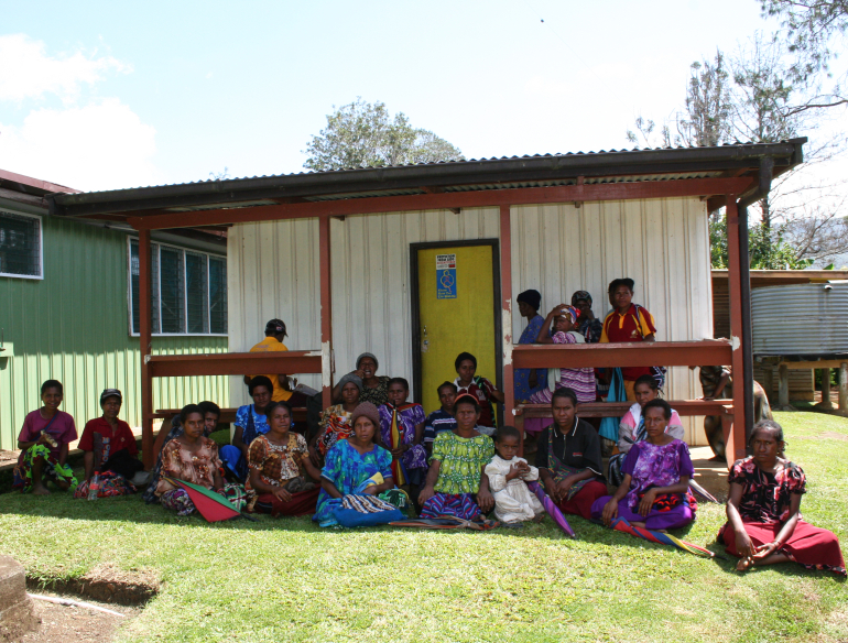 Group of women from Papua New Guinea PNG, sitting in front of building, village reporters working on informing and recruiting community. Credit: Andrew Vallely