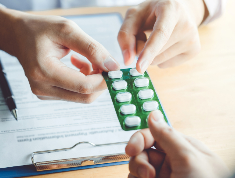 Doctor giving a patient blister pack of pills. Credit: AdobeStock