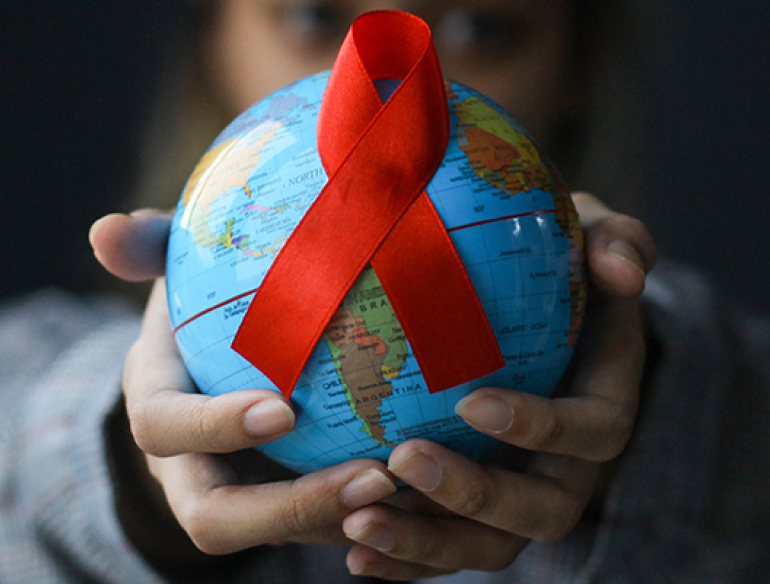 Hands with globe with red ribbon