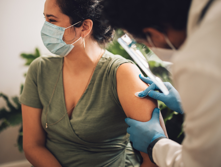 Doctor giving a vaccination to a woman. Credit: AdobeStock