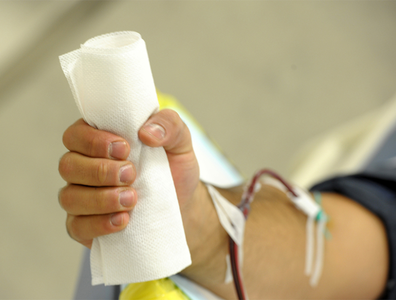 Hand of white man clenching bandages