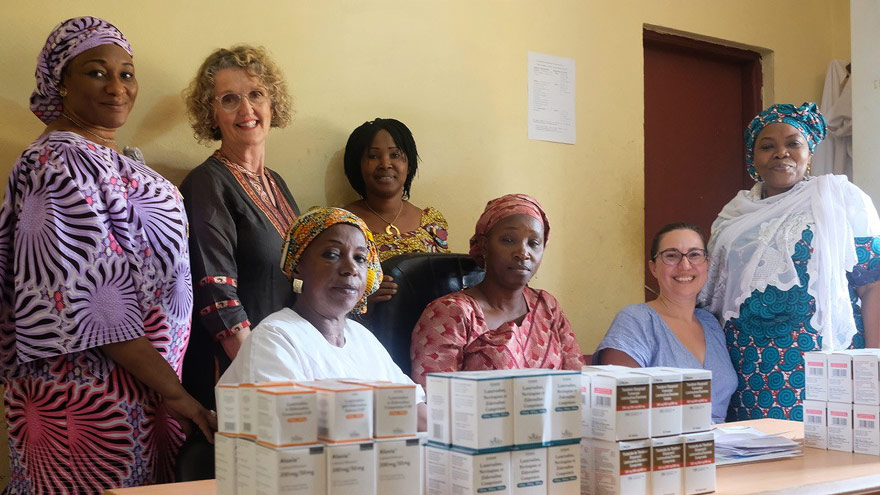 DNU. D²EFT trial coordinators and Kirby researchers in Guinea, standing in front of a table of HIV medication. 