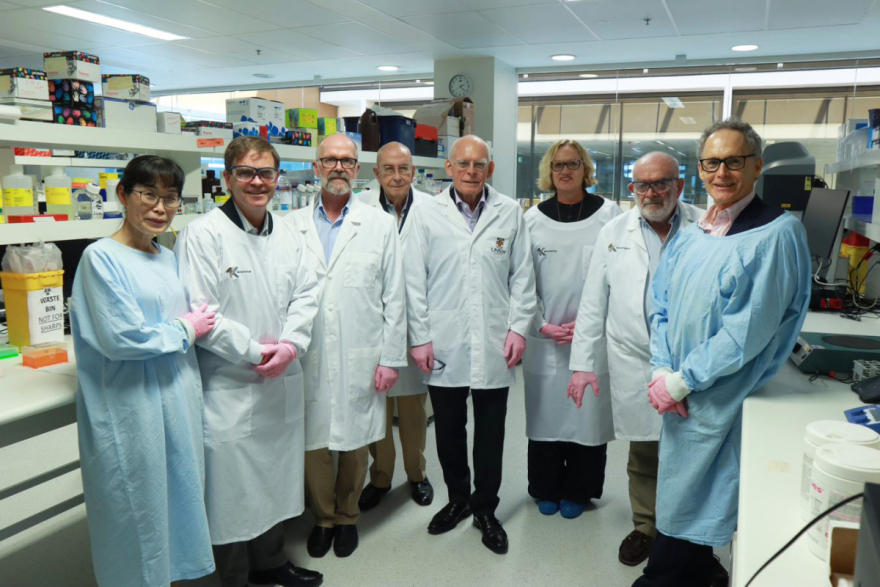 Lord Glendonbrook and members from the Glendonbrook Foundation with Kirby researchers, all wearing lab coats inside the laboratory.
