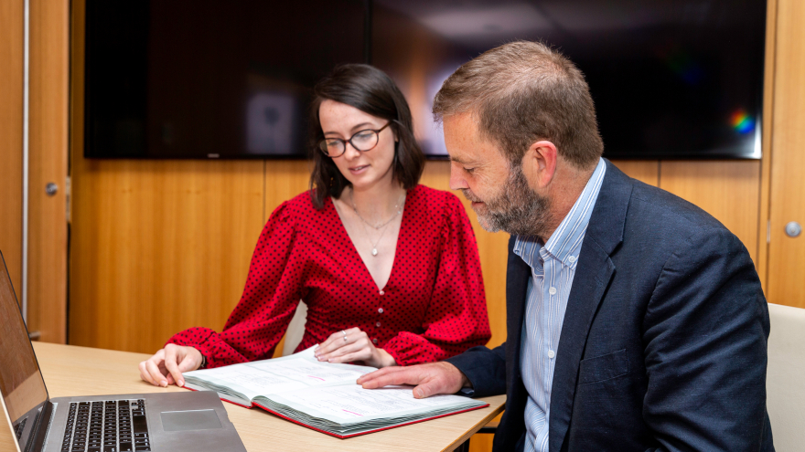 Supervisor with PhD student meeting, both looking at notes in notebook. Credit: Kirby Institute/Bec Lewis.