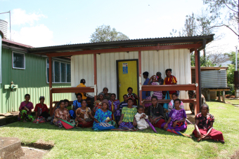Group of women from Papua New Guinea PNG, sitting in front of building, village reporters working on informing and recruiting community. Credit: Andrew Vallely