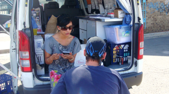 Researcher conducting interview with a community member from the back of a van. 