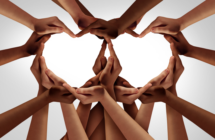 Several diverse coloured hands, forming the shape of two hearts. Credit: Shutterstock
