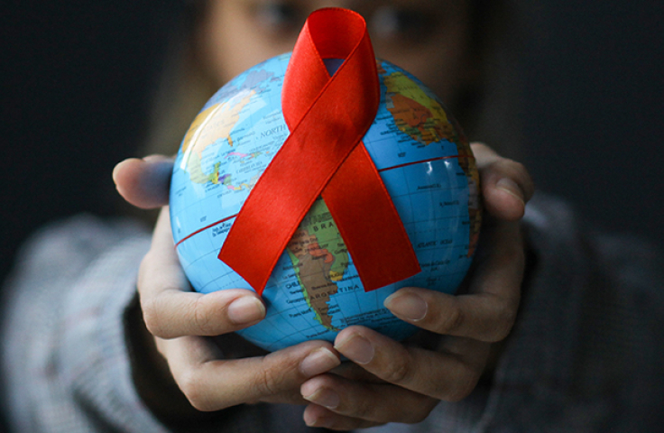 Hands with globe with red ribbon