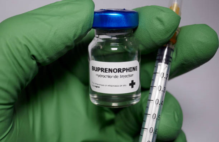Green gloved hand holding buprenorphine and syringe Credit: Hailshadow, iStock