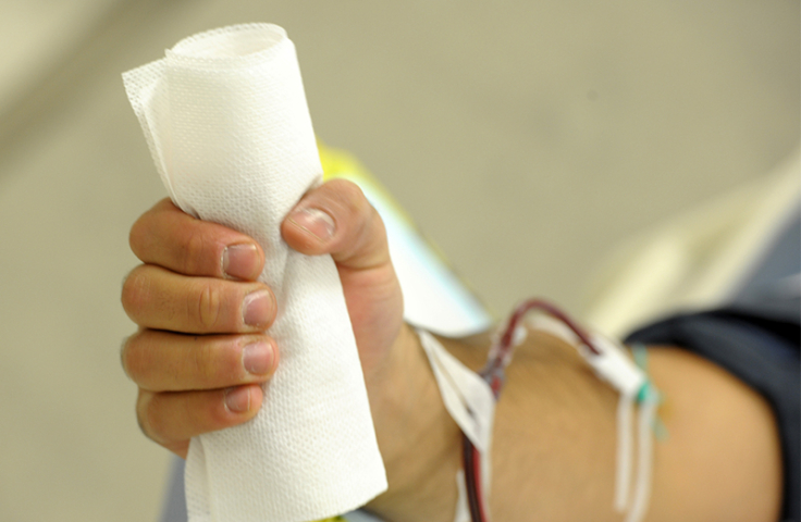 Hand of white man clenching bandages